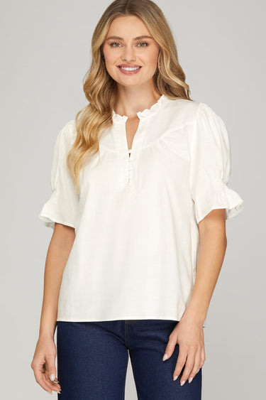 Ivory ruffle blouse at 6whiskey, six whisky, woman wearing white blouse with jeans, ideal for fall game day or tailgate looks at texas a&m, aggies, SEC, gameday outift inspo, ivory soft puff sleeves, button details, front view, football game outfit, watch party look, game day to everyday look. Pair with maroon or burgundy aggie accessories and sneakers, sandals, or booties. Texas A&M aggie style. Everyday casual chic aggie style. Ruffle collar, v-neck, gathered sleeves. Short sleeve blouse.