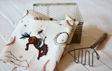 Yeehaw Cowgirl Tea Towel at 6Whiskey six whisky tirzah lane art hand drawn hande made stars roping cowgirl bucking horse horseshoe mountain pattern printed white home goods home decor kitchen towel