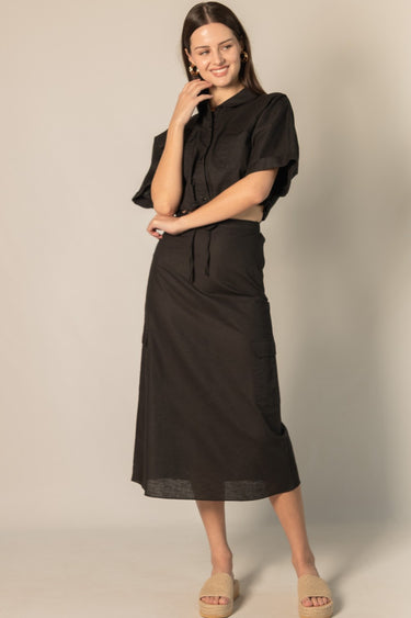 Black Linen Cargo Skirt by Pcill at 6Whiskey, six whiskey, pockets, back elastic waistband, cool girl, elegant western, casual, breathable, tailored, concert, dinner date, night out, matching set. Front view.