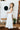 The Prairie Lace Dress by Tasha Polizzi at 6Whiskey, six whisky, Paris dress, white maxi dress, tiered, embroidery, delicate, elegant, feminine, western, chic, stylish, it girl, country concert, rodeo, church, lunch, two stepping, concho button, ruffle hemline, ruffle neckline, flowy, flattering. Side view.