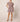 Aurora Mini Dress at 6Whiskey six whisky Cleobella. A woman wearing a short, flutter-sleeve mini dress with a high neckline, removable waist sash, and an allover floral print in earthy tones; the dress features a ruffled hem and side pockets, styled with brown ankle-strap sandals.