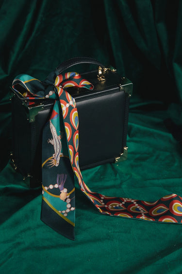 Peacock Silk Twilly at 6Whiskey, six whisky, green, blue, red, yellow, white, pearl, peacock design, flowing design, blues, greens, bold, vibrant, likely, personality, exciting, refined, eye-catching, colorful, pop of color, western accessory, rodeo, multicolor, handbag accessory, neck scarf, front view