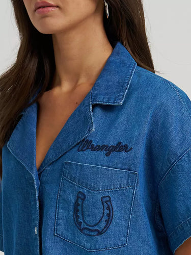 Cowboy Spirit Camp Shirt by Wrangler at 6Whiskey, six whisky, Women’s embroidered denim camp shirt, front pocket, embroidered, horseshoe, wrangler logo, bucking bronco rider on the back, front button closure, wide collar, flowy short sleeves, cropped length, soft, comfortable, lightweight, warm weather, spring, summer, casual western, modern, front pocket embroidery view