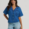 Cowboy Spirit Camp Shirt by Wrangler at 6Whiskey, six whisky, Women’s embroidered denim camp shirt, front pocket, embroidered, horseshoe, wrangler logo, bucking bronco rider on the back, front button closure, wide collar, flowy short sleeves, cropped length, soft, comfortable, lightweight, warm weather, spring, summer, casual western, modern, front view