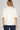Ivory ruffle blouse at 6whiskey, six whisky, woman wearing white blouse with jeans, ideal for fall game day or tailgate looks at texas a&m, aggies, SEC, gameday outift inspo, ivory soft puff sleeves, back view, football game outfit, watch party look, game day to everyday look. Pair with maroon or burgundy aggie accessories and sneakers, sandals, or booties. Texas A&M aggie style. Everyday casual chic aggie style. Ruffle collar, gathered sleeves. Short sleeve blouse. 