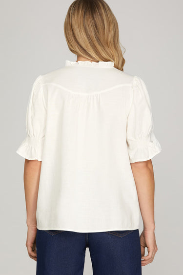 Ivory ruffle blouse at 6whiskey, six whisky, woman wearing white blouse with jeans, ideal for fall game day or tailgate looks at texas a&m, aggies, SEC, gameday outift inspo, ivory soft puff sleeves, back view, football game outfit, watch party look, game day to everyday look. Pair with maroon or burgundy aggie accessories and sneakers, sandals, or booties. Texas A&M aggie style. Everyday casual chic aggie style. Ruffle collar, gathered sleeves. Short sleeve blouse. 
