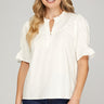 Ivory ruffle blouse at 6whiskey, six whisky, woman wearing white blouse with jeans, ideal for fall game day or tailgate looks at texas a&m, aggies, SEC, gameday outift inspo, ivory soft puff sleeves, button details, front view, football game outfit, watch party look, game day to everyday look. Pair with maroon or burgundy aggie accessories and sneakers, sandals, or booties. Texas A&M aggie style. Everyday casual chic aggie style. Ruffle collar, v-neck, gathered sleeves. Short sleeve blouse. 