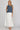 Dotted denim top at 6whiskey, six whisky, woman wearing blue and white polka dot top and white skirt, ideal for fall game day or tailgate looks at texas a&m, aggies, SEC, gameday outift inspo, sleeveless top, polka dots, front view, football game outfit, watch party look, game day to everyday look. Pair with maroon or burgundy aggie accessories and sneakers, sandals, or booties. Texas A&M aggie style. Everyday casual chic aggie style. sleeveless top for fall fashion. 