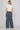 Dotted denim pants at 6whiskey, six whisky, woman wearing blue and white polka dot pants, ideal for fall game day or tailgate looks at texas a&m, aggies, SEC, gameday outift inspo, wide leg pants, polka dots, back view, football game outfit, watch party look, game day to everyday look. Pair with maroon or burgundy aggie accessories and sneakers, sandals, or booties. Texas A&M aggie style. Everyday casual chic aggie style. flowy pants for fall fashion. Pockets, stretchy waist band.