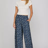Dotted denim pants at 6whiskey, six whisky, woman wearing blue and white polka dot pants, ideal for fall game day or tailgate looks at texas a&m, aggies, SEC, gameday outift inspo, wide leg pants, polka dots, front view, football game outfit, watch party look, game day to everyday look. Pair with maroon or burgundy aggie accessories and sneakers, sandals, or booties. Texas A&M aggie style. Everyday casual chic aggie style. flowy pants for fall fashion. Pockets, stretchy waist band.