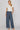 Dotted denim pants at 6whiskey, six whisky, woman wearing blue and white polka dot pants, ideal for fall game day or tailgate looks at texas a&m, aggies, SEC, gameday outift inspo, wide leg pants, polka dots, front view, football game outfit, watch party look, game day to everyday look. Pair with maroon or burgundy aggie accessories and sneakers, sandals, or booties. Texas A&M aggie style. Everyday casual chic aggie style. flowy pants for fall fashion. Pockets, stretchy waist band.