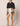 Sebastian Shorts at 6whiskey by Cleobella, high-rise fit, front pleats, placed floral print, decorative button detail, cotton linen blend, tailored silhouette, breathable fabric, women's shorts, summer statement piece.