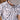 Close-up of a man wearing the Texas Standard Outlaw Traditions Shirt, featuring a white base with bold Texas-themed illustrations including cowboy boots, oil rigs, longhorn skulls, sheriff badges, and cacti, styled with a classic collar and pearl snaps