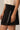 Piping Black Mini Skirt by P.cill at 6Whiskey, six whiskey, white side piping, high elastic waistband, comfy, cozy, sporty, elevated, classy, chic, sleek, matching set, pickleball, errands, loungewear. Side view.