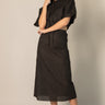 Black Linen Cargo Skirt by Pcill at 6Whiskey, six whiskey, pockets, back elastic waistband, cool girl, elegant western, casual, breathable, tailored, concert, dinner date, night out, matching set. Front view.