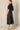 Black Linen Cargo Skirt by Pcill at 6Whiskey, six whiskey, pockets, back elastic waistband, cool girl, elegant western, casual, breathable, tailored, concert, dinner date, night out, matching set. Back view.