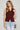 Woman wearing a maroon sleeveless knit vest with gold buttons and light-wash jeans, styled for Texas A&M game day and fall tailgates at 6whiskey six whisky