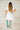 6Whiskey six whisky Woman wearing a short white lace western dress with puff sleeves and tiered skirt, styled with turquoise cowboy boots—perfect for bridal showers, country concerts, or summer events in Texas.