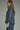 Denim darling blouse at 6whiskey, six whisky, woman wearing a blue denim blouse with jeans, ideal for fall game day or tailgate looks at texas a&m, aggies, SEC, gameday outift inspo, ruffle detail blouse, elasticated gathered long sleeve blouse, side view, football game outfit, watch party look, game day to weekday look. Pair with maroon or burgundy accessories and sneakers, sandals, or boots. Texas A&M aggie style. Casual chic aggie style.