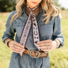 Down south twilly at 6whiskey, six whisky, Texas A&M maroon burgundy western icon graphic, maroon and white, soft, lightweight, breathable, comfortable, accessory, scarf, twilly, ribbon, gameday, tailgating, football, SEC, western, casual. Front view. Woman wearing denim and twilly around neck. Tie on neck, wrist, beltloops, or on purse. Aggie style and gameday outfit inspo. Horseshoe, boots, bucking horse and cowboy.