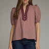 Gridiron gingham blouse at 6whiskey, six whisky, woman wearing a burgundy maroon gingham print blouse with jeans, ideal for fall game day or tailgate looks at texas a&m, aggies, SEC, gameday outift inspo, ruffle detail blouse, elasticated gathered mid length sleeve blouse, front view, football game outfit, watch party look, game day to everyday look. Pair with black, white, or blue jean denim or aggie accessories and sneakers, sandals, or boots. Texas A&M aggie style. Casual chic aggie style. 