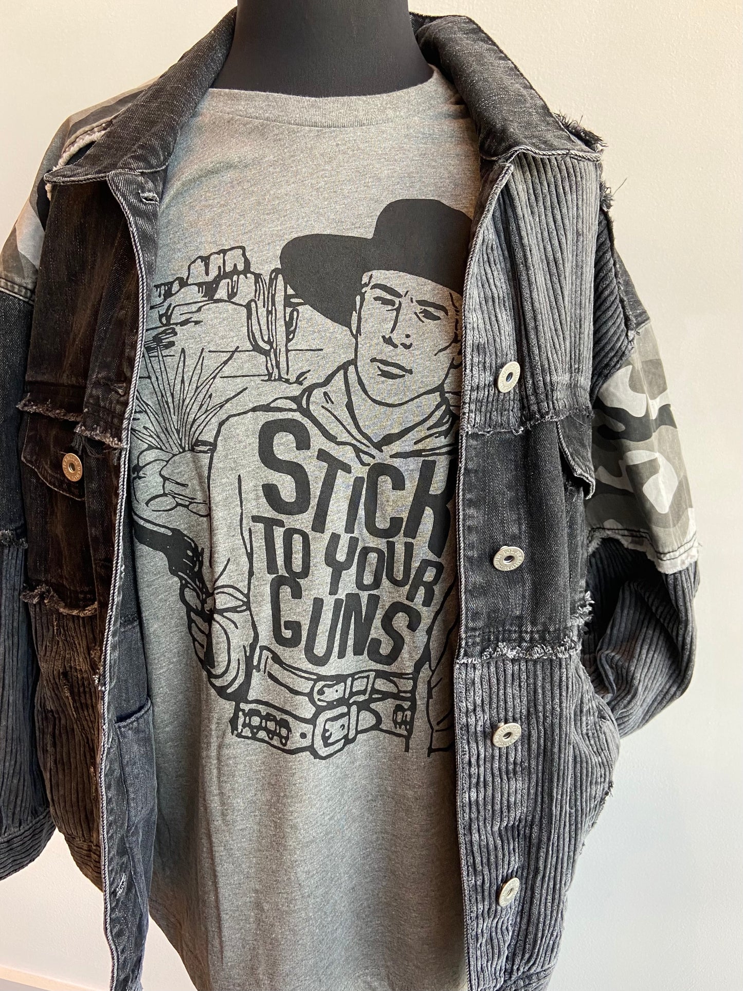 Grey graphic tshirt with black letters and cowboy saying stick to your guns short sleeve at 6Whiskey six whisky mens or womens bella canvas soft tee
