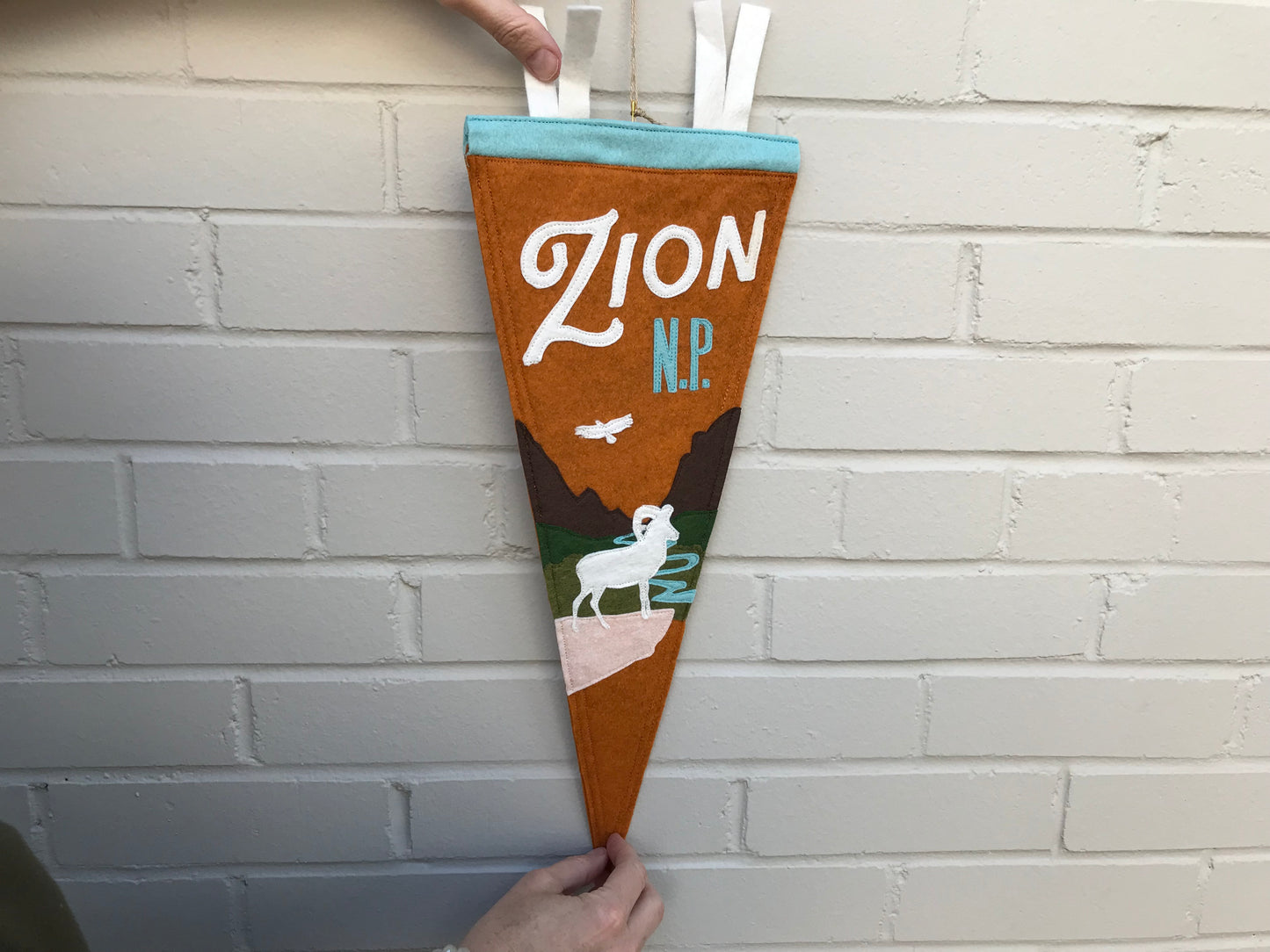 Load image into Gallery viewer, Zion National Park Handmade Felt Pennant at 6Whiskey six whisky in burt orange with ram and moutains
